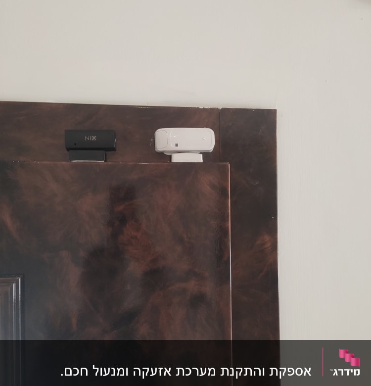 שני מנעולים מגנטיים על דלת עץ כהה